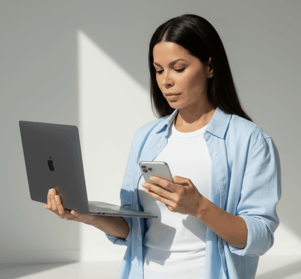 Donna professionista con smartphone e laptop che rappresenta lo sviluppo web ed e-commerce: creare siti che attraggono clienti e generano vendite online.